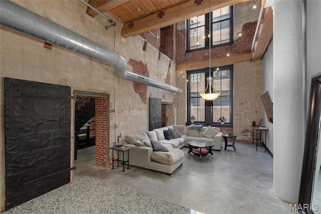 1113 Washington Ave Unit 215, Saint Louis, MO 63101 - living area featuring a towering ceiling, a fireplace, concrete floors, and beam ceiling