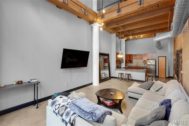 1113 Washington Ave Unit 215, Saint Louis, MO 63101 - living area with a towering ceiling, ornate columns, and beam ceiling