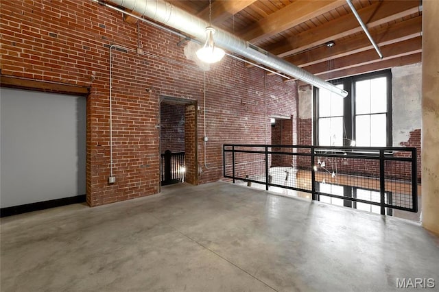 1113 Washington Ave Unit 215, Saint Louis, MO 63101 - spare room featuring finished concrete floors, a wooden ceiling with exposed beams, and a high ceiling