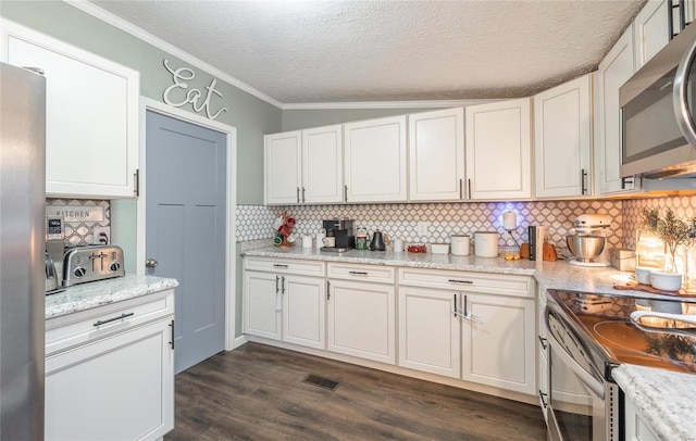 704 Ogle Dr, Richland, MO 65556 - kitchen featuring appliances with stainless steel finishes, backsplash, dark wood-style flooring, ornamental molding, and white cabinets