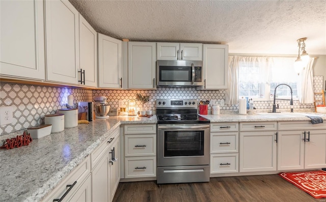 704 Ogle Dr, Richland, MO 65556 - kitchen featuring stainless steel appliances, a sink, a textured ceiling, dark wood-style flooring, and decorative backsplash