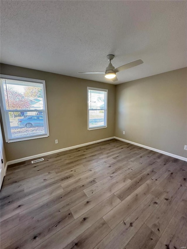 926 Justice Ct, Florissant, MO 63034 - spare room featuring wood finished floors, a textured ceiling, ceiling fan, and baseboards