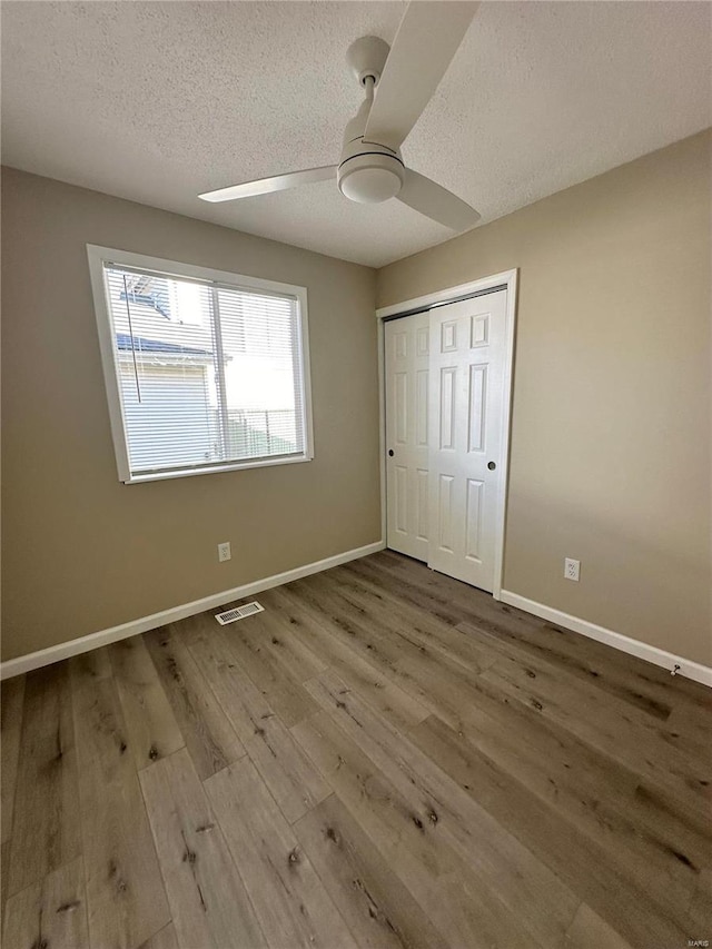 926 Justice Ct, Florissant, MO 63034 - unfurnished bedroom with a textured ceiling, wood finished floors, baseboards, a closet, and ceiling fan