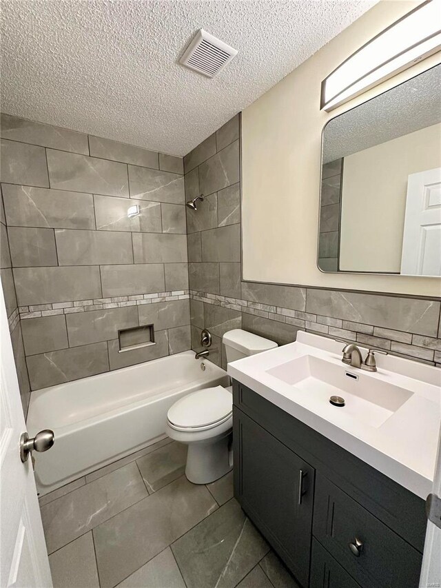 926 Justice Ct, Florissant, MO 63034 - full bathroom featuring a textured ceiling, toilet, shower / tub combination, vanity, and tile walls