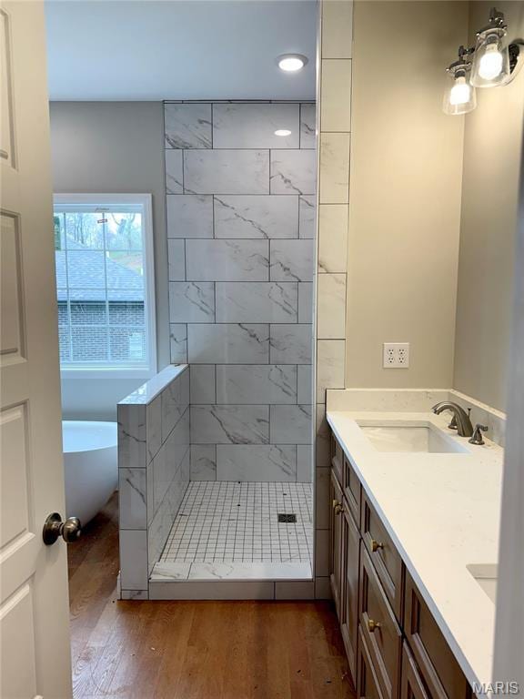 1905 Wheelwright Dr, Cape Girardeau, MO 63701 - bathroom featuring a freestanding tub, wood finished floors, a stall shower, double vanity, and recessed lighting
