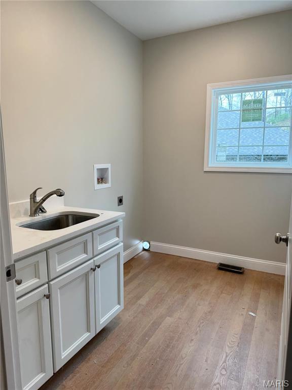 1905 Wheelwright Dr, Cape Girardeau, MO 63701 - laundry room with electric dryer hookup, baseboards, hookup for a washing machine, light wood-style floors, and cabinet space