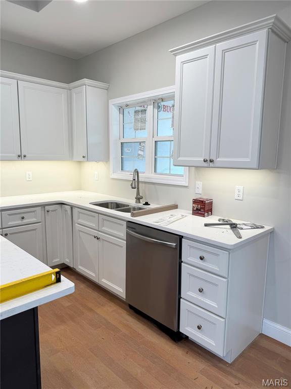 1905 Wheelwright Dr, Cape Girardeau, MO 63701 - kitchen with dishwasher, light wood-type flooring, a sink, white cabinets, and light countertops