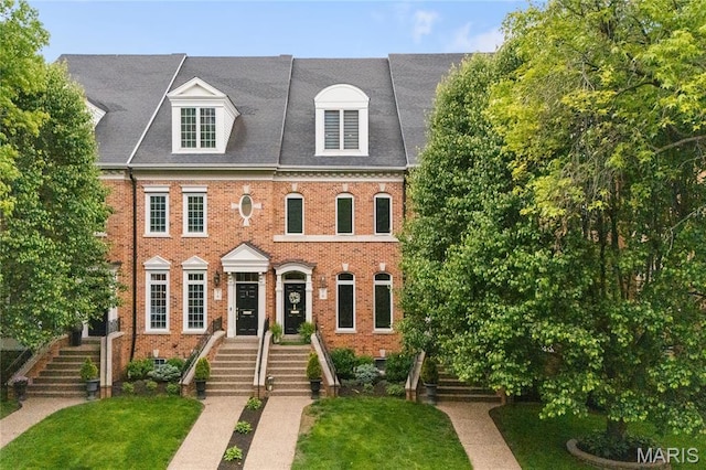 view of front of house featuring brick siding and a front lawn
