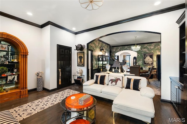 living room with arched walkways, a chandelier, crown molding, wood finished floors, and baseboards