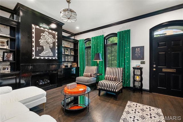 living area with crown molding, wood finished floors, and baseboards