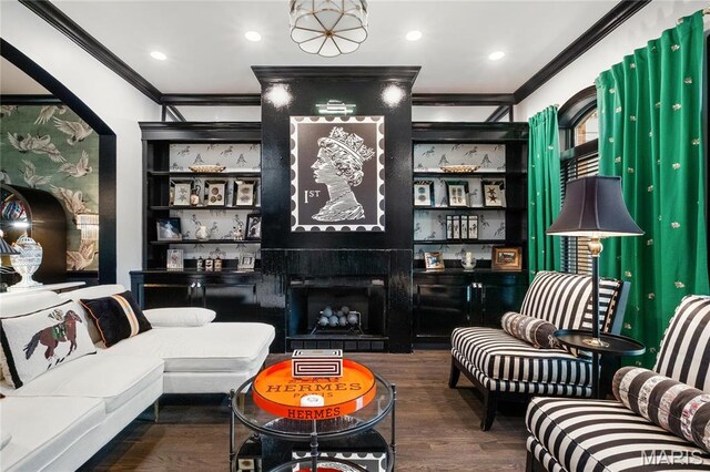 living area with crown molding, wood finished floors, a large fireplace, and recessed lighting