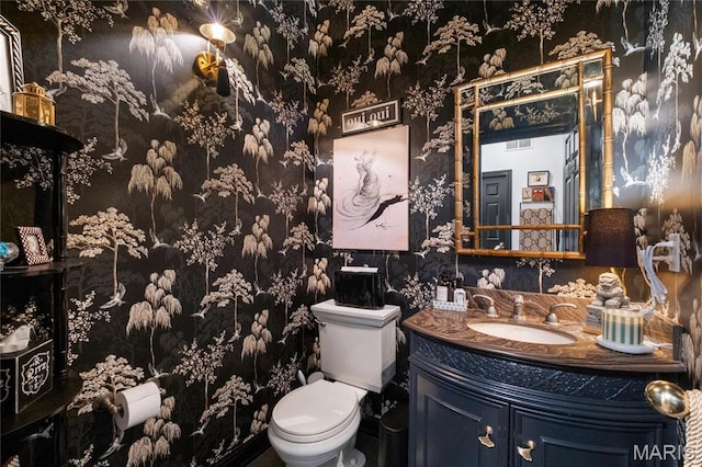bathroom featuring wallpapered walls, toilet, and vanity