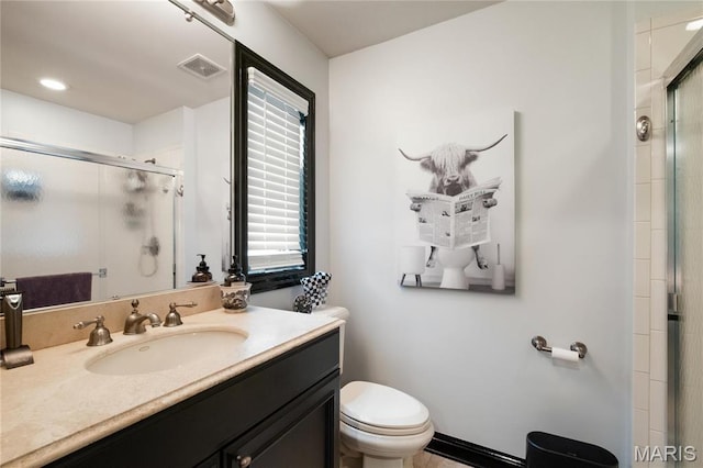 bathroom with a stall shower, toilet, and vanity