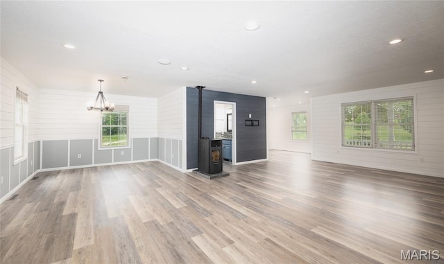 14280 County Road 8100, Rolla, MO 65401 - unfurnished living room featuring a wood stove, a chandelier, wood finished floors, and recessed lighting