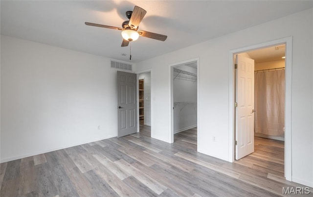 14280 County Road 8100, Rolla, MO 65401 - unfurnished bedroom with wood finished floors, a closet, a spacious closet, a ceiling fan, and baseboards