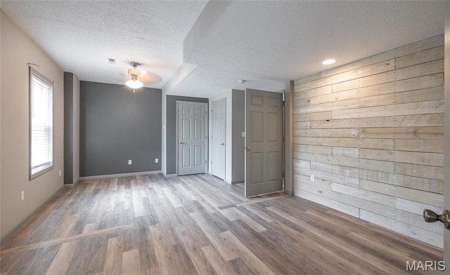 14280 County Road 8100, Rolla, MO 65401 - spare room with a ceiling fan, a textured ceiling, wood finished floors, wood walls, and baseboards