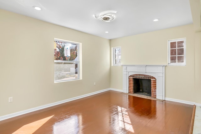 4327 Nelson Dr, Saint Louis, MO 63121 - unfurnished living room featuring wood finished floors, a brick fireplace, baseboards, and recessed lighting