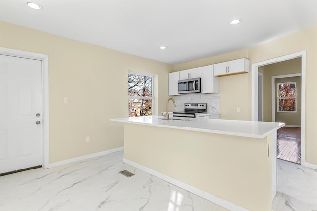 4327 Nelson Dr, Saint Louis, MO 63121 - kitchen with stainless steel appliances, a sink, light marble finish flooring, baseboards, and recessed lighting