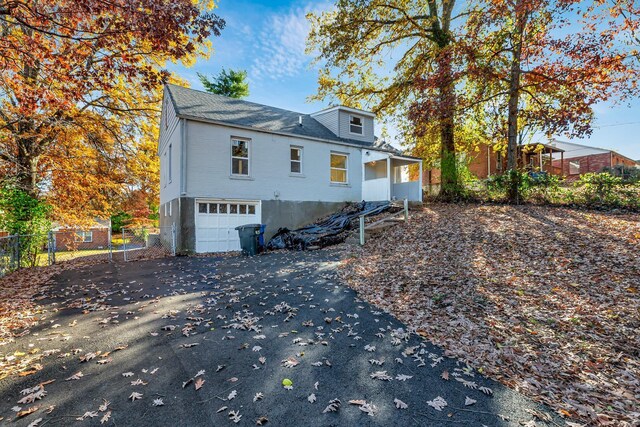 4327 Nelson Dr, Saint Louis, MO 63121 - rear view of house with driveway, an attached garage, fence, and a shingled roof