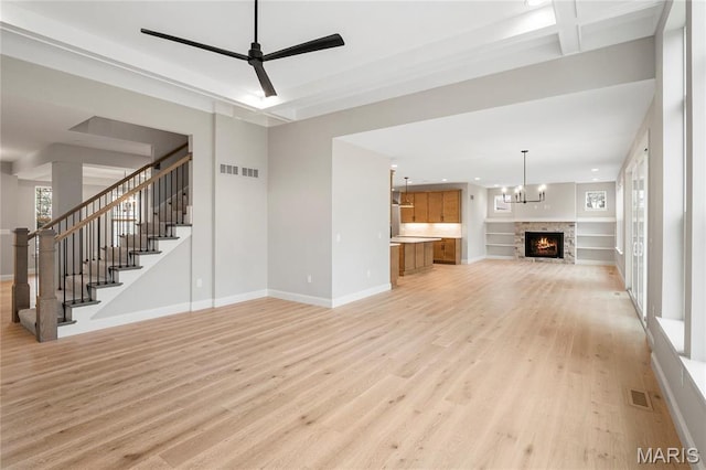 19 Beaver Dr, Creve Coeur, MO 63141 - unfurnished living room with light wood-style flooring, stairs, baseboards, a lit fireplace, and recessed lighting