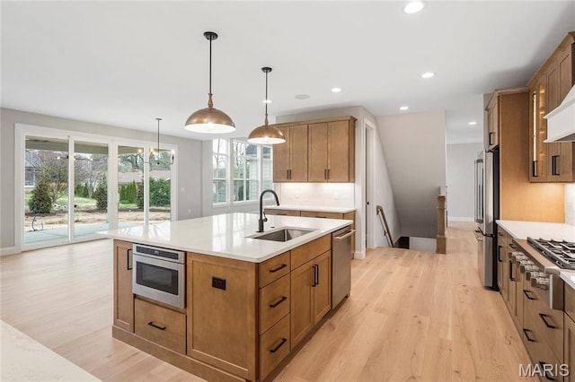19 Beaver Dr, Creve Coeur, MO 63141 - kitchen with a sink, appliances with stainless steel finishes, light wood-type flooring, light countertops, and a kitchen island with sink
