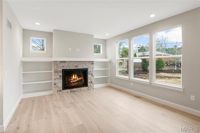 19 Beaver Dr, Creve Coeur, MO 63141 - unfurnished living room with baseboards, a stone fireplace, wood finished floors, recessed lighting, and built in features