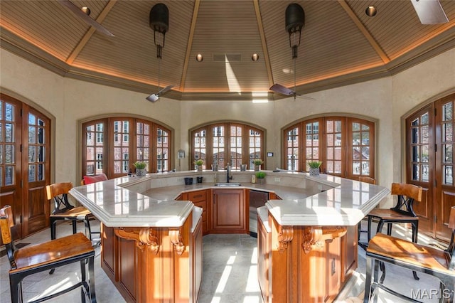 1290 Dry Ridge Rd, Town And Country, MO 63131 - kitchen with high vaulted ceiling, a wooden ceiling with exposed beams, a large island with sink, light countertops, and french doors