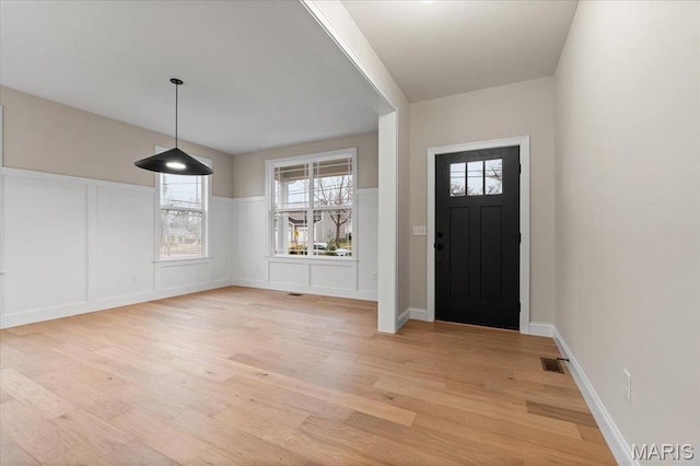 710 Angenette Ave, Kirkwood, MO 63122 - foyer entrance featuring light wood finished floors, a decorative wall, wainscoting, and plenty of natural light