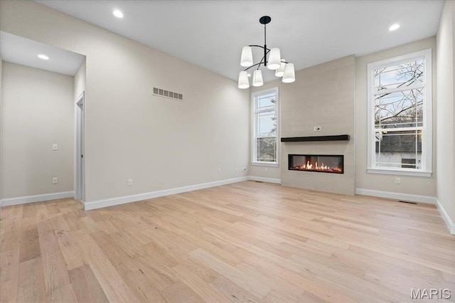 710 Angenette Ave, Kirkwood, MO 63122 - unfurnished living room with plenty of natural light, light wood-type flooring, a chandelier, and recessed lighting