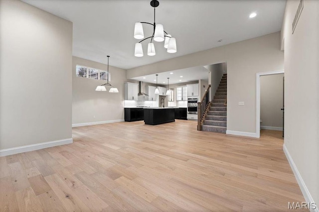 710 Angenette Ave, Kirkwood, MO 63122 - kitchen with open floor plan, a chandelier, light countertops, white cabinets, and a center island