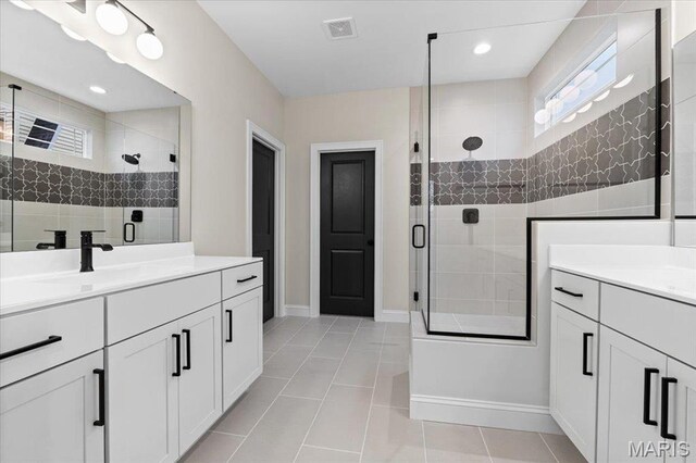 710 Angenette Ave, Kirkwood, MO 63122 - bathroom with healthy amount of natural light, a stall shower, and two vanities