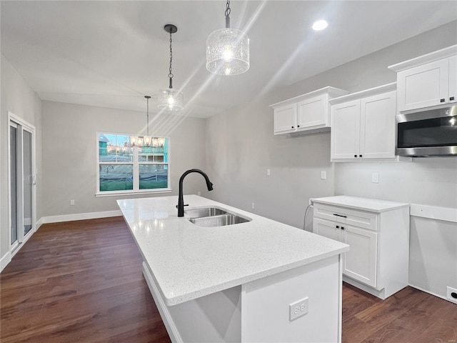 205 Stonebridge Bluff Dr, Maryville, IL 62062 - kitchen with stainless steel microwave, a sink, white cabinets, dark wood-type flooring, and a kitchen island with sink