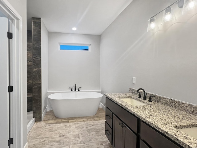 205 Stonebridge Bluff Dr, Maryville, IL 62062 - full bathroom with double vanity, marble look tile flooring, a tile shower, a soaking tub, and baseboards