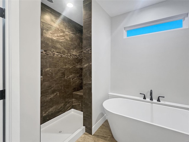 205 Stonebridge Bluff Dr, Maryville, IL 62062 - bathroom with a tile shower, a freestanding tub, and baseboards