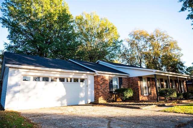 single story home featuring asphalt driveway, a garage, and brick siding