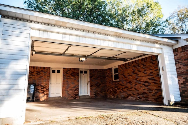 doorway to property featuring brick siding and driveway