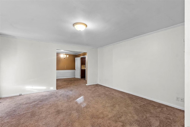 carpeted empty room featuring crown molding and a chandelier