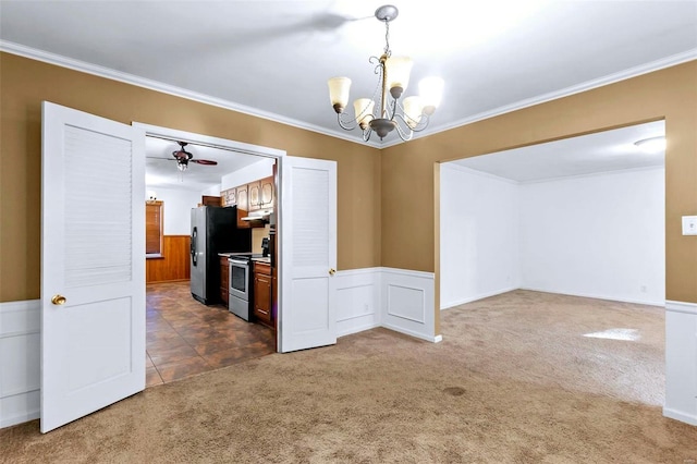 empty room featuring dark carpet, a chandelier, ceiling fan, and crown molding