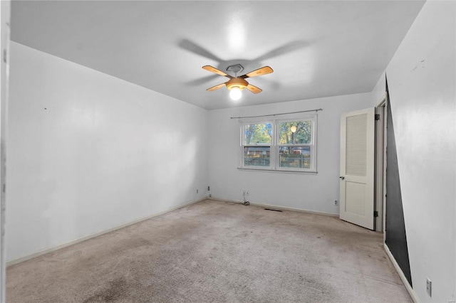 carpeted spare room featuring a ceiling fan