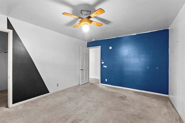 unfurnished room with carpet floors, a ceiling fan, and baseboards