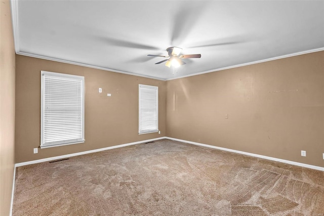 carpeted empty room with crown molding, a ceiling fan, and baseboards
