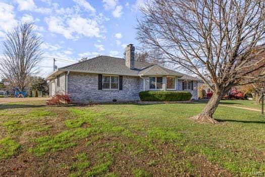825 Cimarron Cir, Farmington, MO 63640 - view of front facade with a chimney, a front lawn, and stone siding