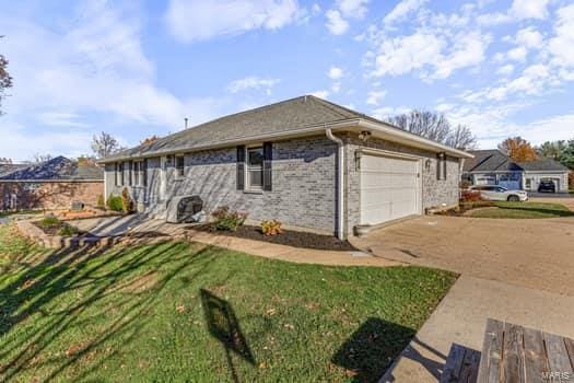 825 Cimarron Cir, Farmington, MO 63640 - view of front of house featuring a garage, driveway, and a front lawn