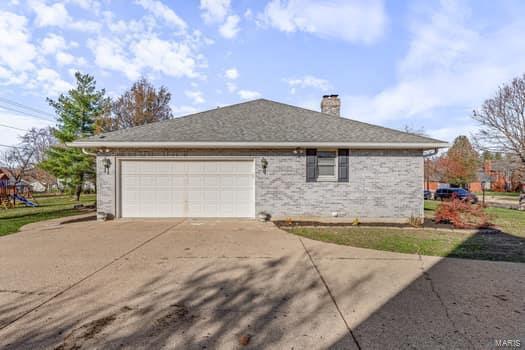 825 Cimarron Cir, Farmington, MO 63640 - view of home's exterior with concrete driveway, an attached garage, and a chimney