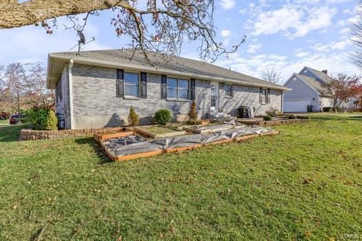 825 Cimarron Cir, Farmington, MO 63640 - back of property with a lawn and a garden