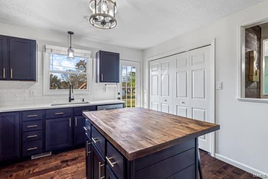 825 Cimarron Cir, Farmington, MO 63640 - kitchen featuring butcher block countertops, blue cabinets, a sink, and healthy amount of natural light