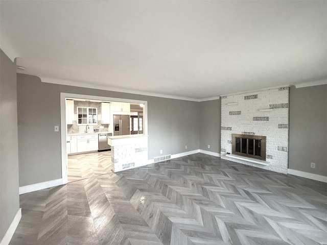 5011 Courtside Dr, Imperial, MO 63052 - unfurnished living room with baseboards, a fireplace, crown molding, and a sink
