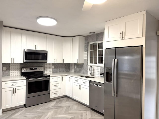 5011 Courtside Dr, Imperial, MO 63052 - kitchen featuring stainless steel appliances, a sink, light countertops, white cabinets, and tasteful backsplash