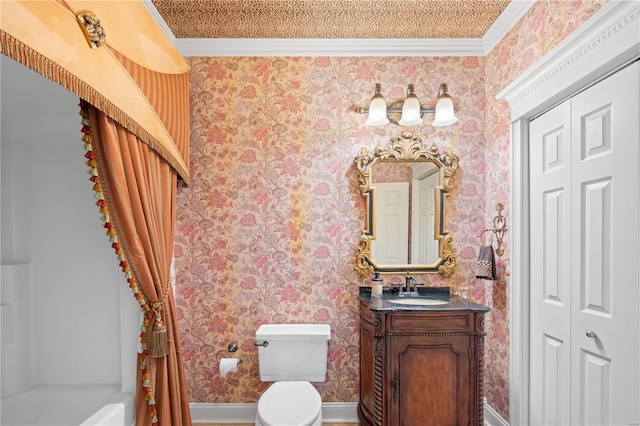 bathroom featuring ornamental molding, wallpapered walls, toilet, vanity, and baseboards
