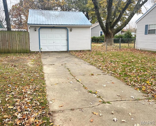 garage featuring driveway and fence